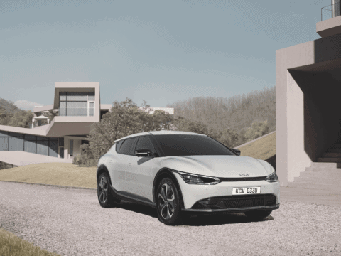 Coche eléctrico moderno en entorno urbano con arquitectura contemporánea.
