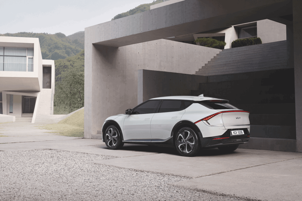 Coche eléctrico de diseño futurista estacionado frente a una estructura moderna y minimalista en un.