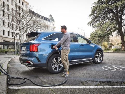 Carga de coche eléctrico en espacio de estacionamiento urbano.