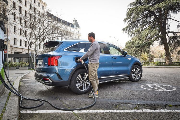 Carga de coche eléctrico en espacio de estacionamiento urbano.