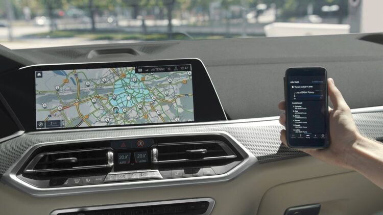 Navegación en coche eléctrico con pantalla y teléfono móvil en el interior del vehículo.