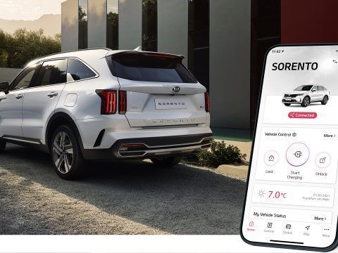 Coche eléctrico Kia Sorento con sistema de control desde app móvil en entorno urbano.