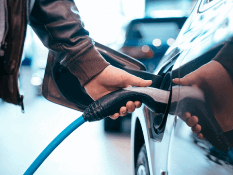 Carga de coche eléctrico en estación de carga rápida.