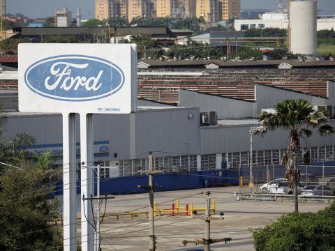 Banda de fábrica de Ford con logo visible en un entorno industrial.
