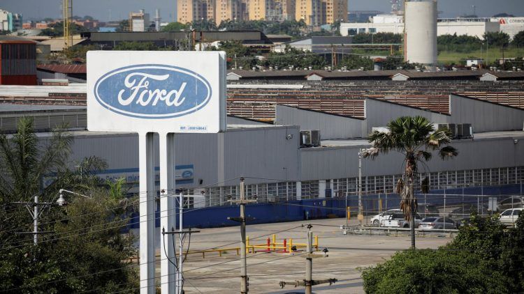 Banda de fábrica de Ford con logo visible en un entorno industrial.