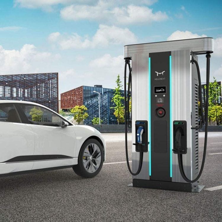Cargador de coches eléctricos en ciudad moderna con vehículo eléctrico conectado, promoviendo movili.