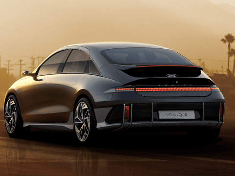 Coche eléctrico de diseño moderno en un aeropuerto durante el atardecer, resaltando innovación y mov.