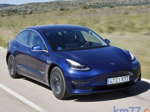Tesla Model 3 azul en carretera eléctrica, coche eléctrico de alta eficiencia y diseño moderno.
