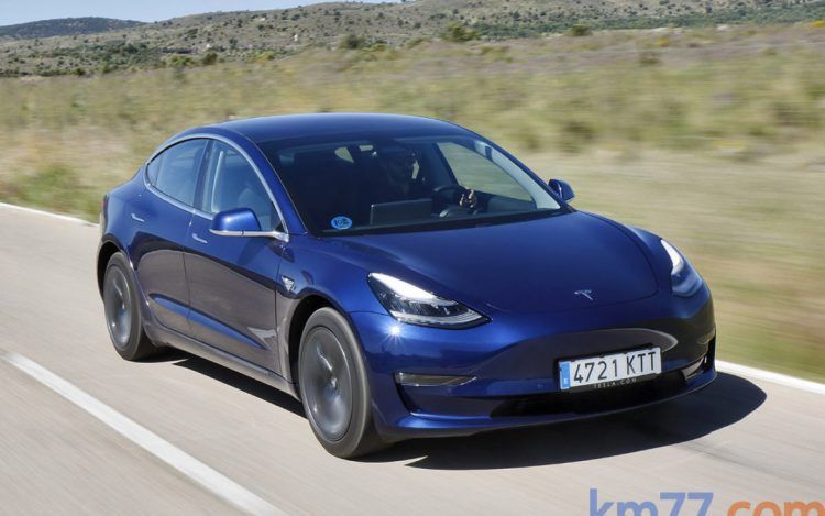 Tesla Model 3 azul en carretera eléctrica, coche eléctrico de alta eficiencia y diseño moderno.