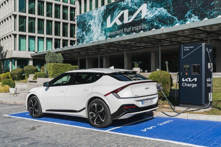 Kia coche eléctrico cargando en estación de carga en ciudad.