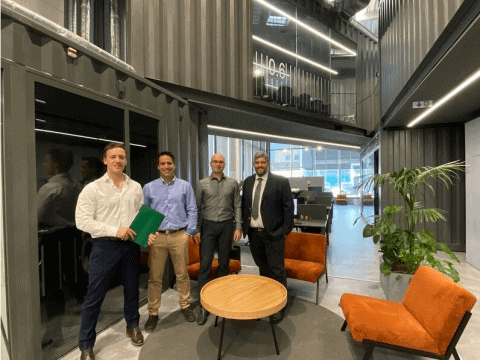 Reunión de profesionales en oficina moderna con mobiliario de diseño y ambiente innovador.