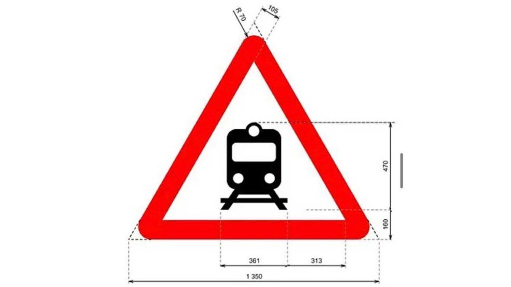 Señal de advertencia de tren en la vía con símbolo de tren en el centro, rodeada por un triángulo ro.