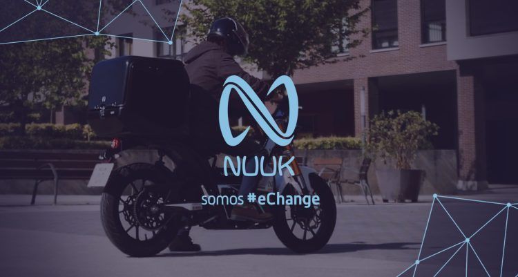 Motociclista con scooter eléctrico NUUK en entorno urbano, promoviendo movilidad sostenible.