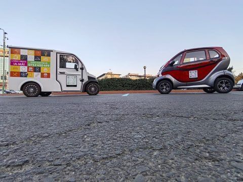 Dos vehículos eléctricos estacionados en línea en una calle urbana.