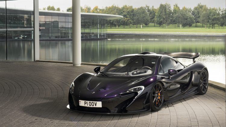 Coche deportivo eléctrico negro con spoiler en entorno urbano moderno.