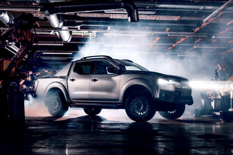 Un coche eléctrico futurista en un taller de fabricación con humo y luces de neón.
