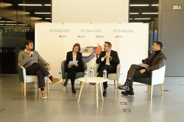 Boceto de una mesa redonda sobre vehículos eléctricos en un evento de movilidad sostenible.