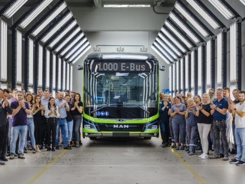 Grupo de personas celebrando la llegada de un autobús eléctrico en un centro de pruebas.