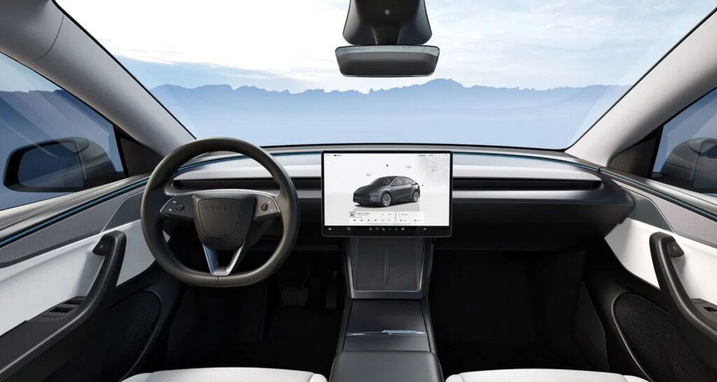Interior de coche eléctrico con pantalla táctil y volante moderno.