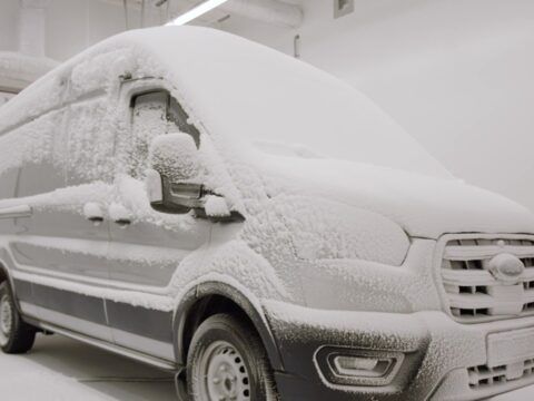 Camión eléctrico cubierto de nieve en un entorno frío y nevado.