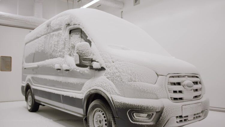 Camión eléctrico cubierto de nieve en un entorno frío y nevado.