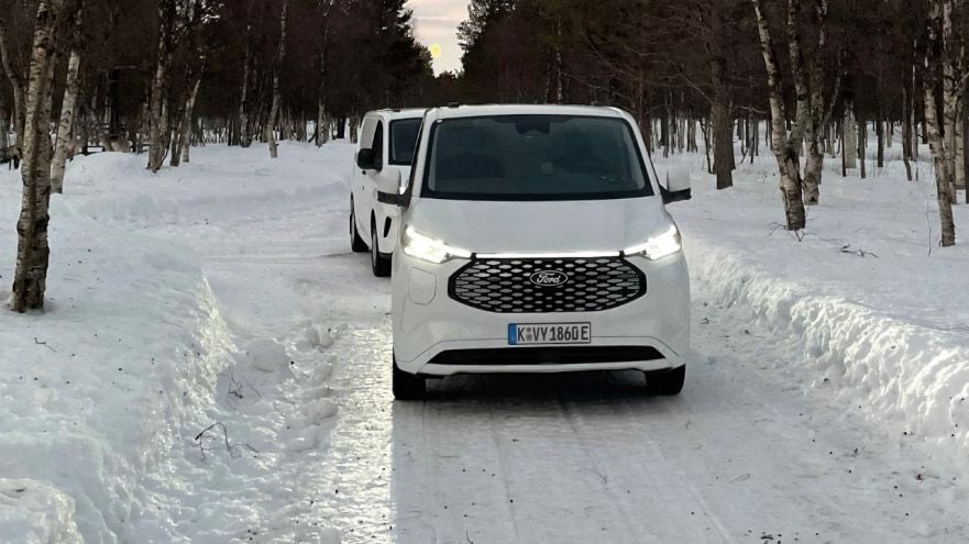 Autonomía de coche eléctrico en nieve, vehículo en camino nevado, movilidad sostenible en inviern.